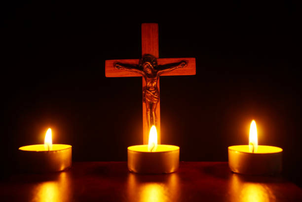 istock Crucifix and three burning candles in the darkness 937311976