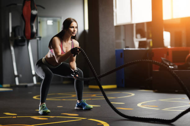 istock Athletic young woman doing gym exercises with a rope. 937322564