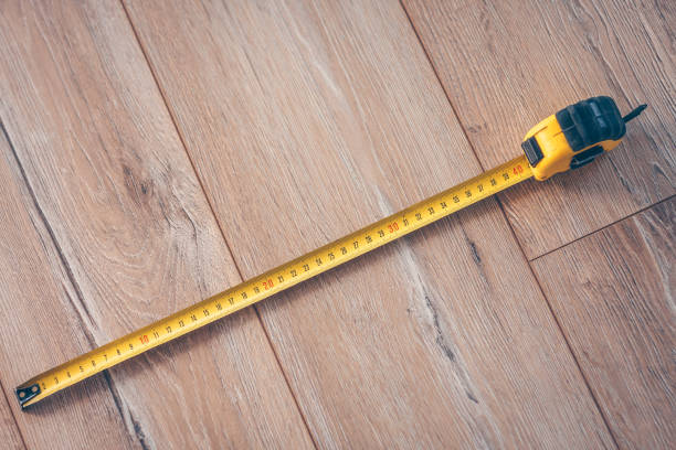 istock Construction tape measure on a wooden floor 937323182