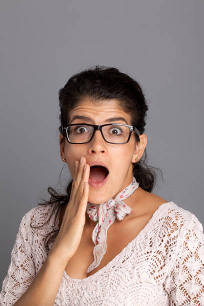 istock Shocked young woman covers her cheek with her hand 937326302