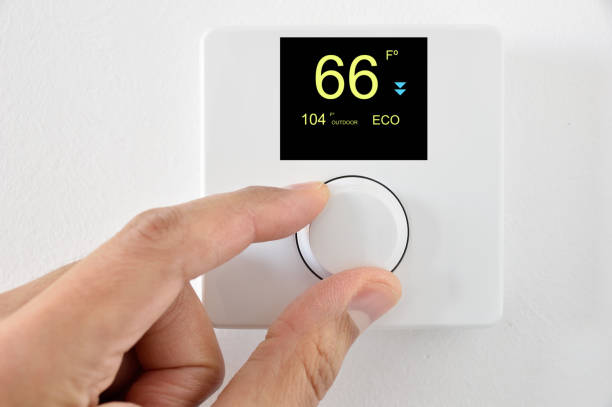 the summer heat arrives One hand adjust thermostat digital in  fahrenheit at home.Home automation smart thermostat photos stock pictures, royalty-free photos & images