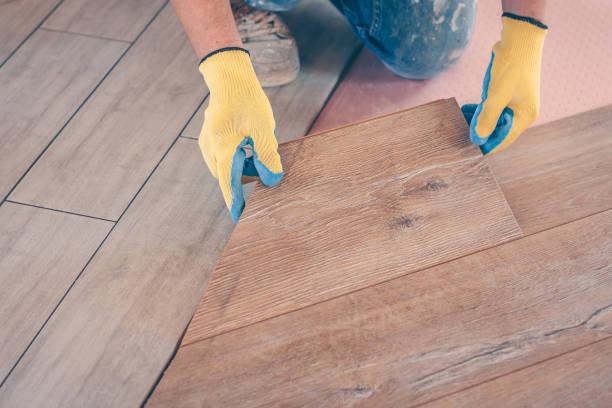 istock Professional installation of floor covering, the worker quickly and qualitatively mounts a laminate board 937327978