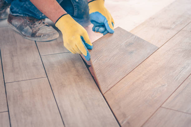 istock Working with hands installs a laminate board, professional flooring installation 937327982
