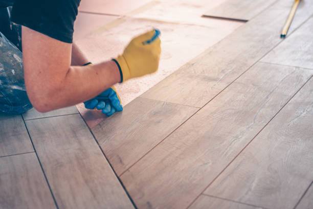 istock Working with hands installs a laminate board, professional flooring installation 937328366
