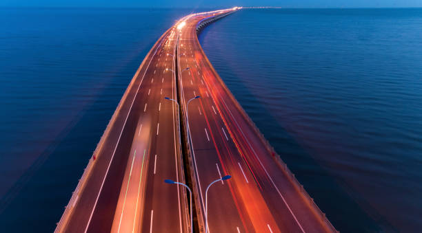 Aerial view of cars on donghai bridge As the only route that links Yangshan Port to other places, 32.5-kilometer-long Donghai Bridge is China's first pelagic cross-sea bridge. sea bridge stock pictures, royalty-free photos & images