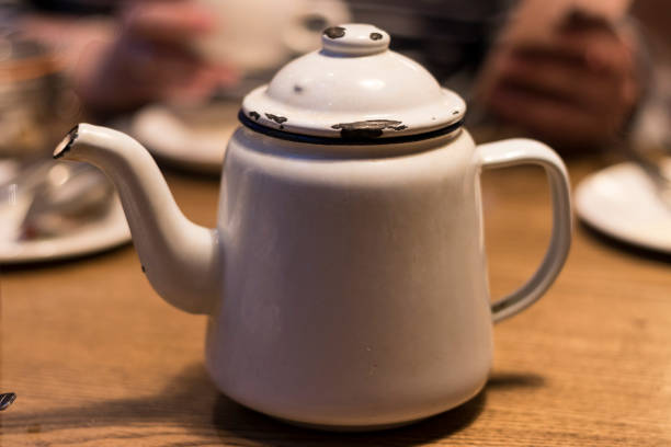Old enamel tea pot, isolated on white