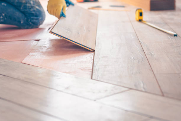 istock Professional installation of floor covering, the worker quickly and qualitatively mounts a laminate board 937349552