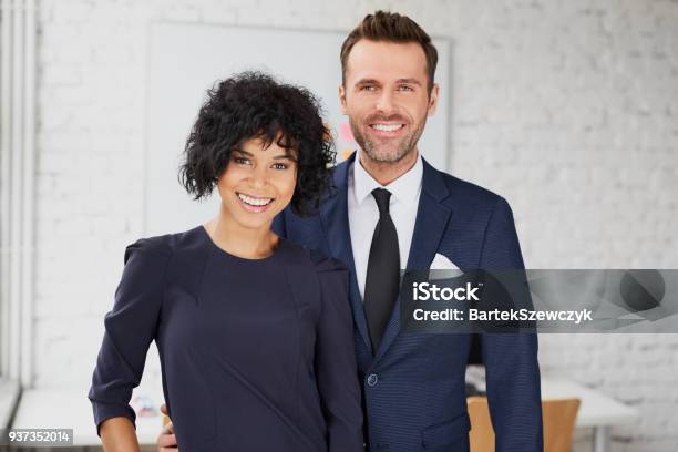 Business Man And Business Woman Standing Together In The Office Stock Photo - Download Image Now