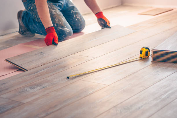 istock Working with hands installs a laminate board, professional flooring installation 937359902