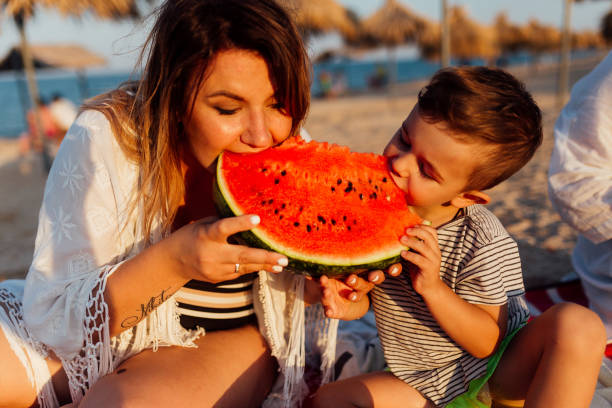 istock Mother and her son eating watermelon 937363254