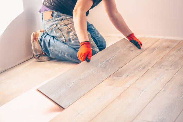 istock Professional installation of floor covering, the worker quickly and qualitatively mounts a laminate board 937364834