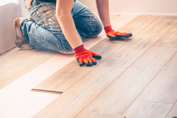 istock Working with hands installs a laminate board, professional flooring installation 937370268