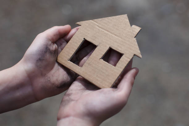 istock homeless boy holding a cardboard house 937374952