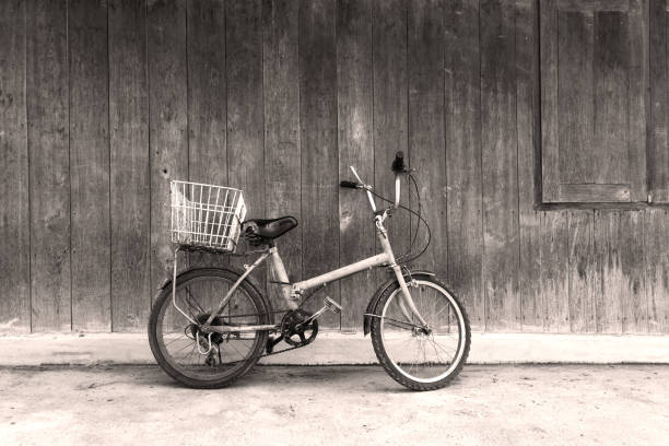 istock Black and white old bicycle leaning against wall 937375526