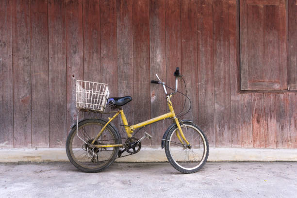 istock Old rusty bicycle leaning against wooden wall 937375706