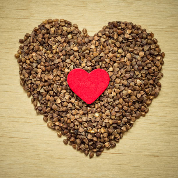 istock buckwheat groats heart shaped on wooden surface. 937376360