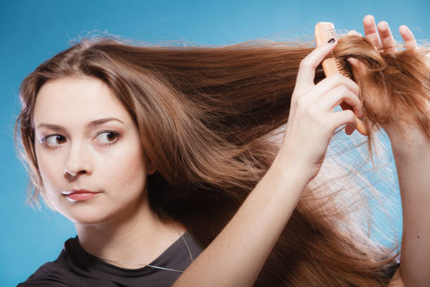 istock Female combing hair with wooden comb 937378460