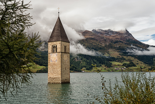 During the lake damming at Reschenpass in Italy, the entire village of Graun sank into the floods of the reservoir. Today only the church tower rising out of the lake Reschensee testifies to the sunken village.