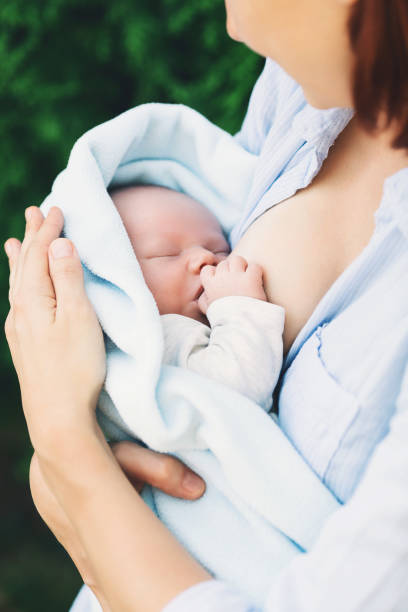 istock Baby eating mother's milk on nature. 937384602