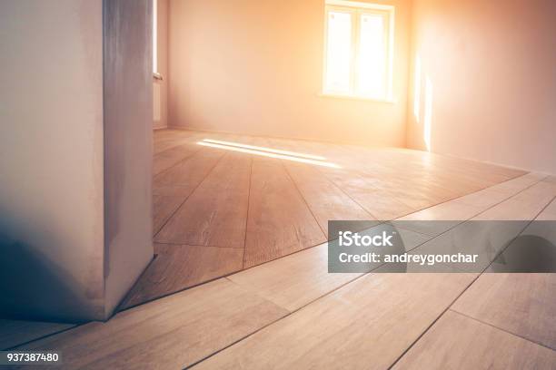 Professional Installation Of Floor Covering The Worker Quickly And Qualitatively Mounts A Laminate Board Stock Photo - Download Image Now