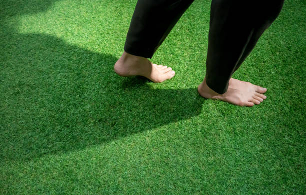 istock Woman legs walking on green grass lawn. 937387660