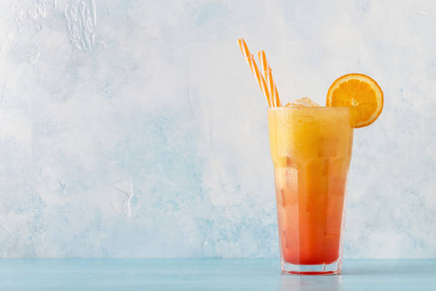 сочный оранжевый и красный текила восход солнца со льдом - drink alcohol juice red стоковые фото и изображения