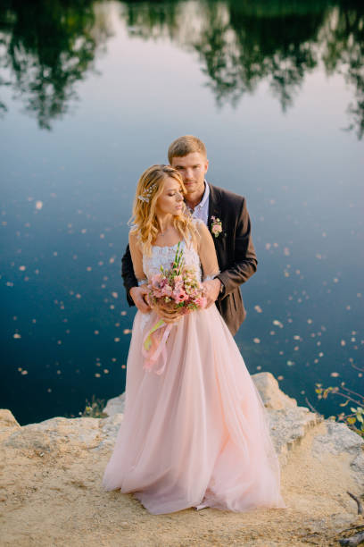 istock newlyweds standing on the lake shore at sunset 937406460