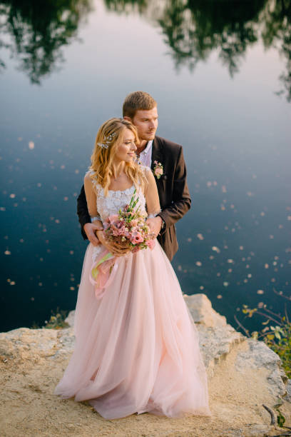 istock newlyweds standing on the lake shore at sunset 937406724