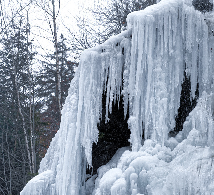 Frozen waterfall with icicles and snow near Bad Harzburg in the fir forests and spruce forests along the main road to Braunlage in the Harz mountains.