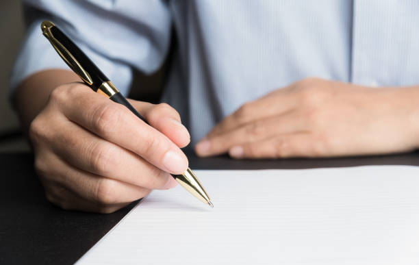 istock Business man Hands with pen writing on paper 937415742