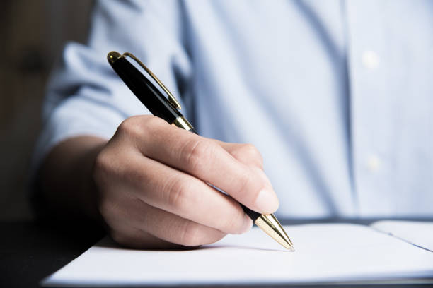 istock Business man Hands with pen writing on paper 937416558