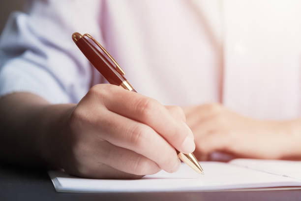 istock Business man Hands with pen writing on paper 937416568