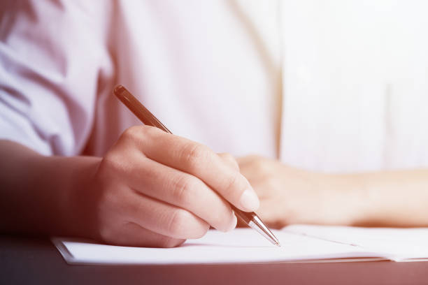 istock Business man Hands with pen writing on paper 937416618