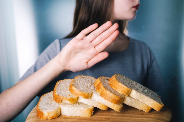 グルテン不耐症の概念。若い女の子白パン - フィールドの浅い深さを食べることを断る - food white caucasian color image ストックフォトと画像