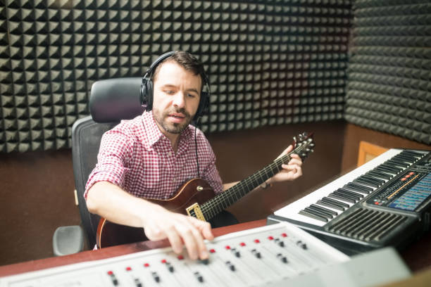 istock Musician fine tuning the sounds in recording studio 937419810