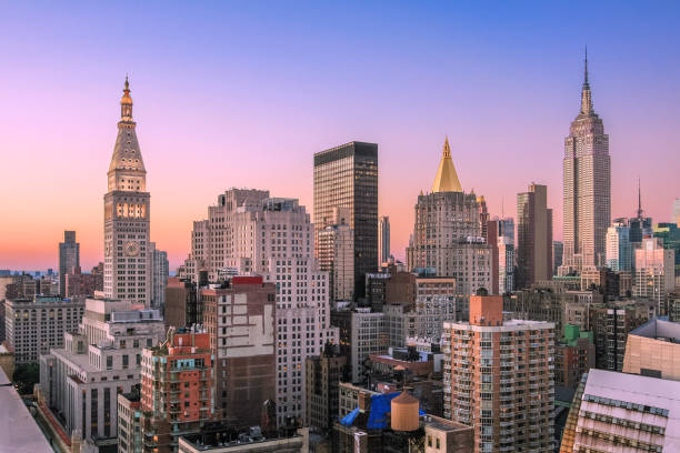 new york city skyline ao entardecer com império estado edifício, metropolitan life insurance company tower, o arranha-céus do midtown manhattan e laranja-azul céu claro. - prédio da metlife - fotografias e filmes do acervo