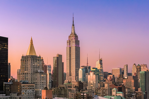 New York City Skyline at Sunset with Empire State Building, Midtown Manhattan Skyscrapers and Clear Sky. Magenta filter.