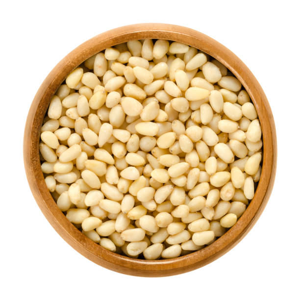 istock Cedar nuts in wooden bowl over white 937427694