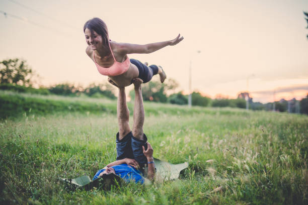 This is fun Man is holding a woman in plank pose acroyoga stock pictures, royalty-free photos & images