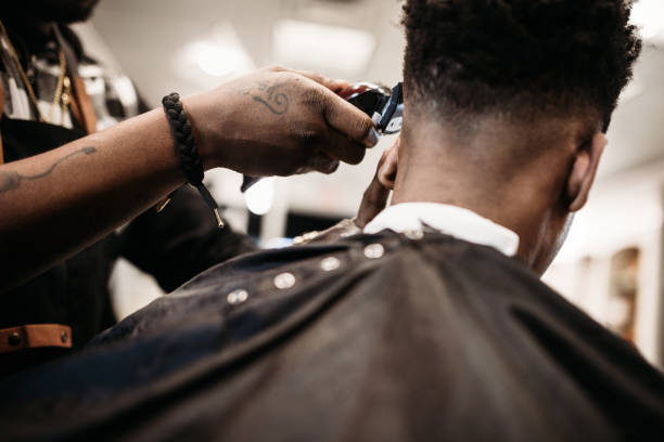barbiere che dà un taglio di capelli nel suo negozio - tagliare i capelli foto e immagini stock