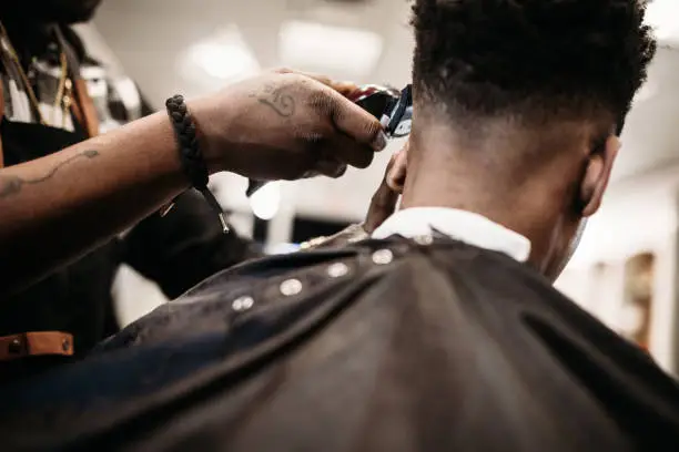 Photo of Barber Giving A Haircut in His Shop