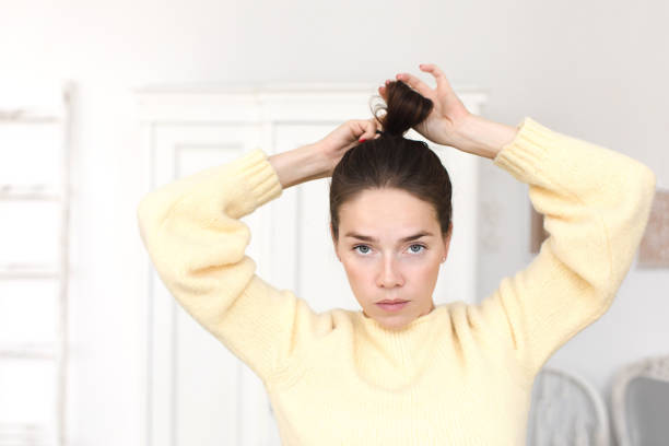 istock Casual woman making hairstyle looking at camera 937450340