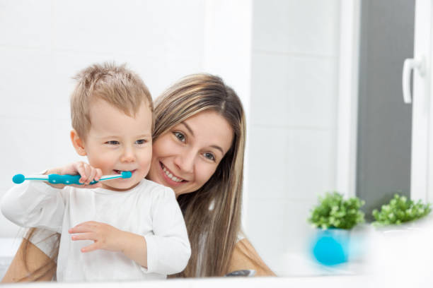 glückliche mutter ihren sohn beizubringen, wie man zähne busch - human teeth child smiling family stock-fotos und bilder