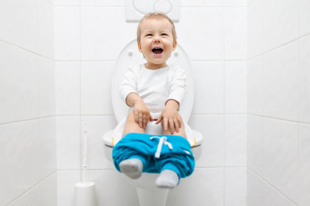 istock Adorable young child sitting on the toilet 937458886