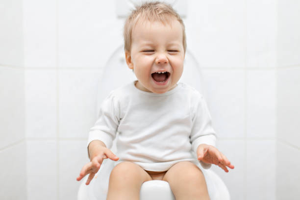 Adorable young child sitting on the toilet Adorable young child sitting and learning how to use the toilet potty toilet child bathroom stock pictures, royalty-free photos & images