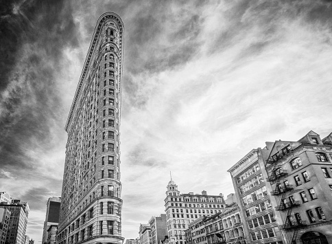 A black and white image looking up at the angular profile of the Flatiron Building in Midtown Manhattan.