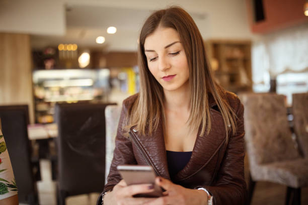 istock Young woman using mobile phone in cafe 937468066
