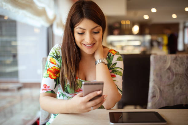 istock Young pregnant woman using mobile phone in cafe 937472672