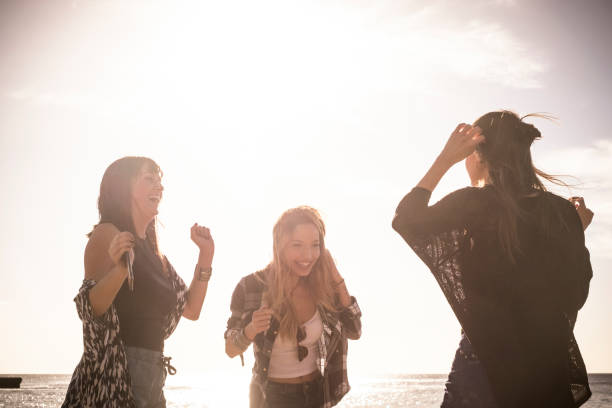 istock Group of three young woman dance on the beach 937474800