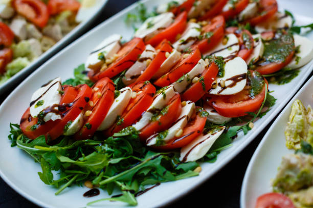 insalata caprese con mozarella, pomodori e basilico - mozarella sul tavolo foto e immagini stock